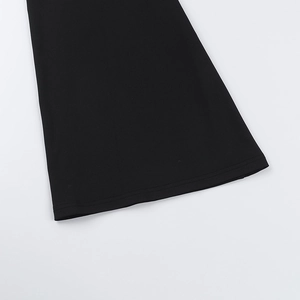 Detailed view of the flared hemline on a black knitted dress with fine stitching