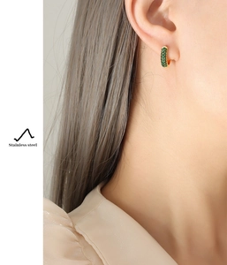 Close-up of gold-plated stainless steel hoop earring with green zircon micro-inlay