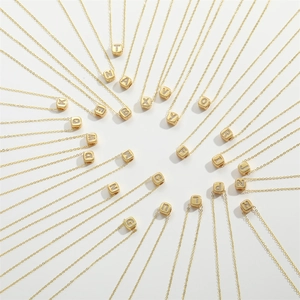 Golden cube initial necklaces with cubic zirconia arranged in a circular pattern