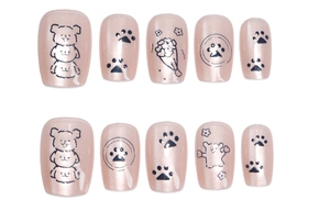 Detail of pink press-on nails with cute cartoon puppy designs and cat-eye glitter finish