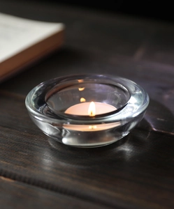Detailopname van een elegante kristallen glazen kandelaar met warm theelicht op houten tafel
