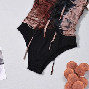 Detailed view of tie-dye pleated fabric texture and lace-up strap on sleeveless bodysuit