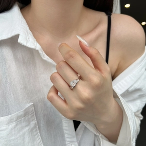 Primo piano di un anello in argento S925 con zircone a goccia e fascia ritorta minimal