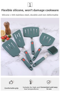 Detail of dark green silicone spatulas and brush with stainless steel handles on marble