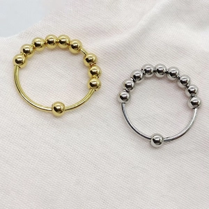 Set of gold and silver stainless steel anxiety rings with rotating metal beads for relief