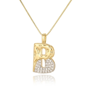 Macro detail of initial B pendant with gold hammered finish and zircon pavé setting