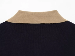 Detailed close-up of contrast color knit polo collar in navy blue and beige fabric