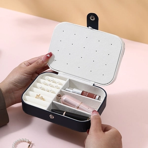 Portable navy blue jewelry storage box with compartments for rings and earrings