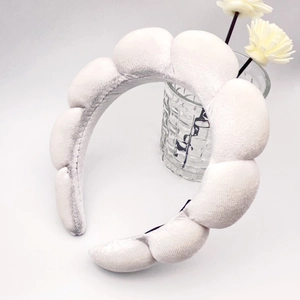 Close-up of white puffy cloud headband with soft velvet texture and wave design