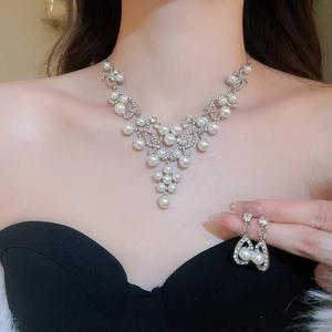 Detailed view of model wearing French style silver teardrop pearl necklace and earring set