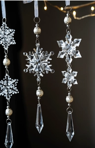 Close-up of transparent acrylic snowflake pendant with white pearls and crystal droplets