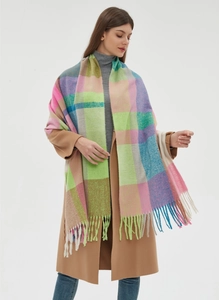 Close-up of thick multi-color plaid scarf with long tassels and soft wool texture