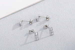 Detailed view of silver stainless steel stud earrings in smooth and textured bar styles