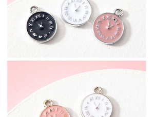 Dettaglio di ciondoli orologio rotondi con numeri romani in smalto nero, bianco e rosa