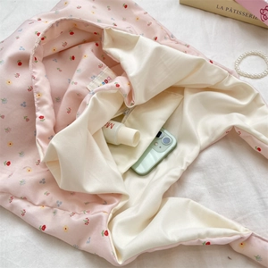 Detail view of pink floral tote bag interior with beige lining and a zipper pocket