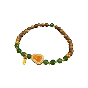 Handmade orange garnet and jasper bead bracelet with a gold gourd pendant on white background