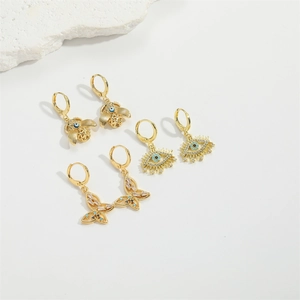 Gold hoop earrings set with bee, evil eye, and butterfly charms and blue zircons