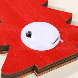 Detail view of the battery compartment and power switch on a red wooden LED Christmas tree