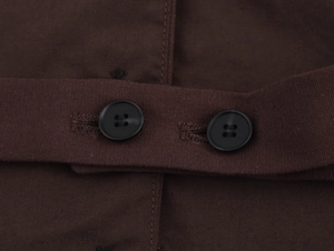 Close-up of dark brown slim-fit vest showing detailed fabric texture and black buttons
