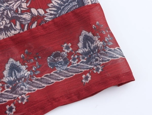 Détail du tissu en mousseline rouge à imprimé floral avec ourlet roulé délicat