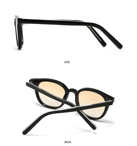 Detail view of retro sunglasses with black frames and orange gradient lenses