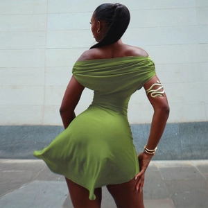 Detail of light green off-shoulder mini dress with silky fabric texture and fluid drape