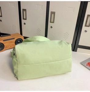 Détail du sac de voyage en nylon vert clair montrant le tissu et les œillets en métal