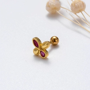 Dettaglio macro di orecchino a farfalla dorato con zircone rosa e chiusura a vite