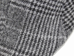 Vue macro du motif pied-de-poule gris et noir avec texture détaillée du tissu en laine