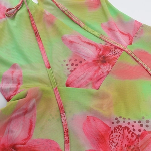 Detail of floral mesh fabric with green and pink patterns showing fine mesh texture