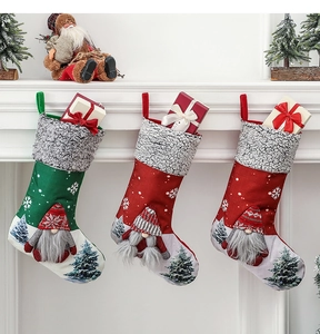 Three festive Christmas stockings with gnomes and snowflakes hanging on a fireplace mantel