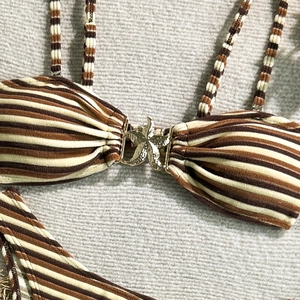 Close-up of brown striped bikini featuring a golden starfish metallic detail and ribbed fabric