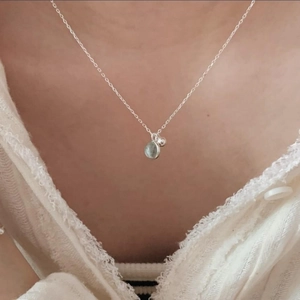 Minimalist 925 sterling silver necklace with light green round crystal pendant on model