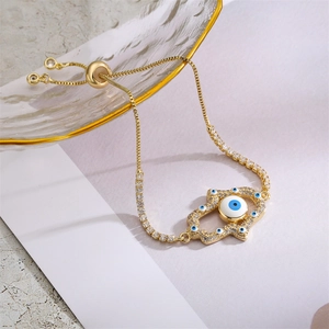 Close-up of golden Hamsa Hand bracelet with blue Evil Eye and pavé cubic zirconia detail