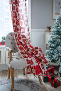 Close-up of red and white plaid Christmas curtain with tassel fringe on a chair