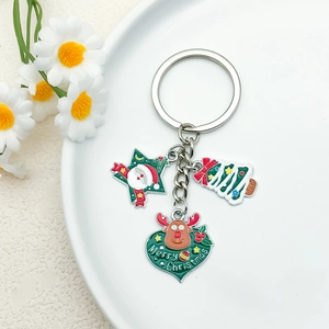 Close-up of Santa Claus, reindeer and Christmas tree enamel pendants on a metal keychain