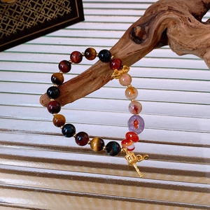 Detailed close-up of tiger eye and agate beads with golden prayer wheel pendant