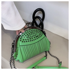 Detail of green shell bag with silver studs, rhinestone fringe and pearl clasp closure