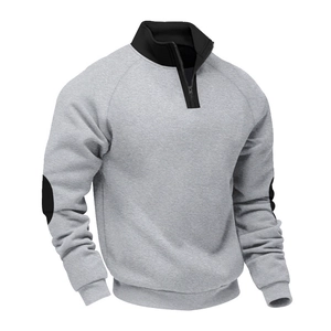 Detailed close-up of color block embroidery and black stand collar on grey sweatshirt