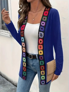 Blue ribbed knit cardigan featuring colorful bohemian floral crochet appliques on a model