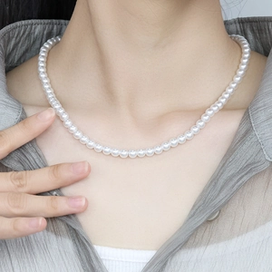 Classic white pearl necklace for women featuring round polished pearls with an elegant drape