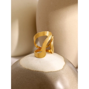 Macro detail of 18k gold irregular wavy ring with brushed metal texture on stone base