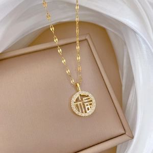 Macro detail of gold titanium necklace with Fu character pendant and crystal inlay