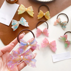 Elegant acetate bow hair ties and clips with marble patterns and faux pearls for high ponytails
