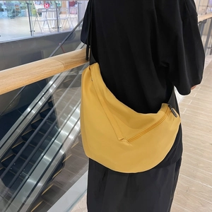 Men's large yellow crossbody dumpling bag made of lightweight nylon shown on model