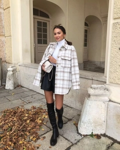 Détail d'une veste chemise à carreaux beige et havane avec deux poches de poitrine en laine