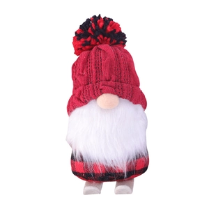 Christmas gnome plush doll with red knitted hat and plaid body on wooden ski base