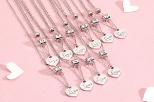 Detail showing ten silver stainless steel necklaces with heart charms and digits on pink