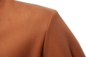 Detail view of the fine texture and neat shoulder stitching on a caramel blazer jacket