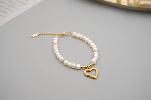 Close-up of freshwater pearl bracelet with golden heart pendant and adjustable chain